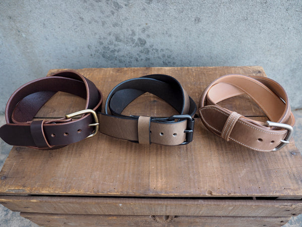 Brown leather 1.5 inch belt with brass rounded buckle.  Grey leather  1.5 inch belt with black stainless roller buckle.  Light brown leather 1.5 inch with white bordering stitch and matte nickel rounded buckle.