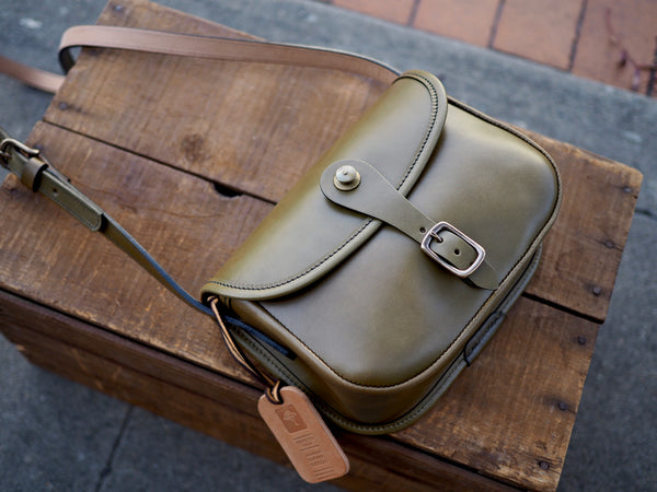 Olive green leather purse with flap.  Solid brass quick release snap and rounded buckle.